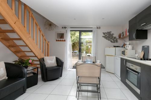 une cuisine et un salon avec une table et des chaises dans l'établissement Le Refuge Salin Duplex Jardin, à Batz-sur-Mer