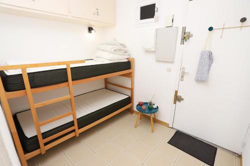 Cette petite chambre comprend des lits superposés et un réfrigérateur. dans l'établissement St Cyprien moderne et confortable proche du port, à Saint-Cyprien