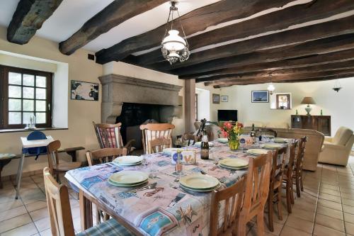 une salle à manger avec une longue table avec des chaises dans l'établissement Gîte Les Croix Gibouins, à Saint-Méloir-des-Ondes