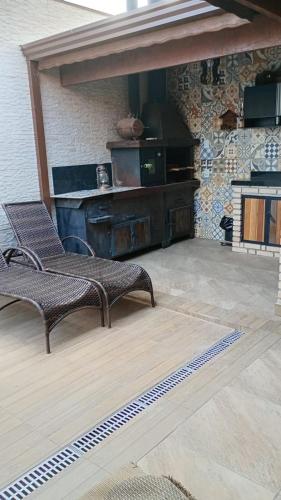 a patio with two chairs and a fireplace at Casa Mairinque São Roque Pq Aquático in Mairinque