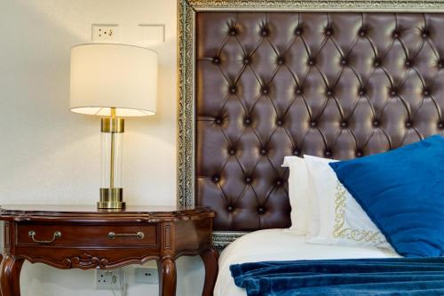 a bedroom with a bed and a lamp on a table at The Diplomat in Midrand