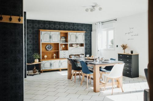 - une cuisine avec une table à manger et des chaises dans l'établissement Cotes et Mer Maison familiale en Bord de Mer, à Urville-Nacqueville