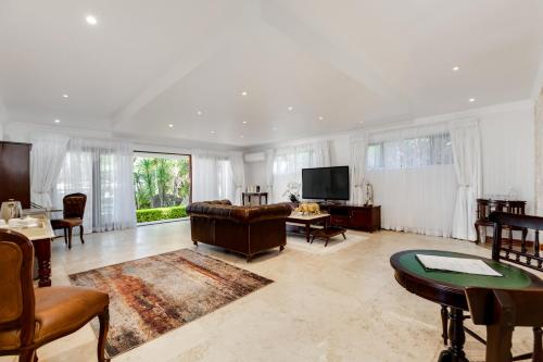 a living room with a couch and a tv at The Diplomat in Midrand