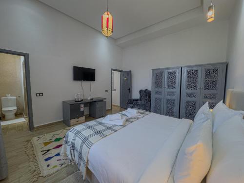a bedroom with a bed and a tv in it at Riad Tonaroz Gold in Marrakech
