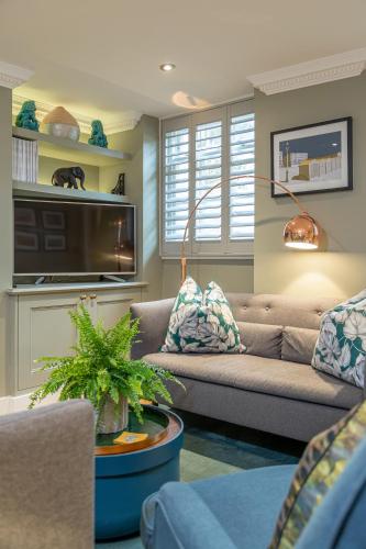 a living room with a couch and a tv at Beaches Brighton - Luxury Seafront Accommodation in Brighton & Hove