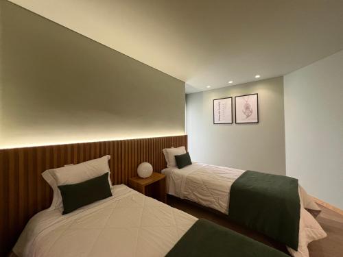 a bedroom with two beds in a room at Casa de Lencastre, Refúgio elegante entre tradição e modernidade in Viana do Castelo