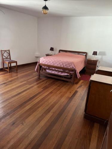 a bedroom with a bed and a wooden floor at Departamento céntrico a dos cuadras de la plaza in Sucre