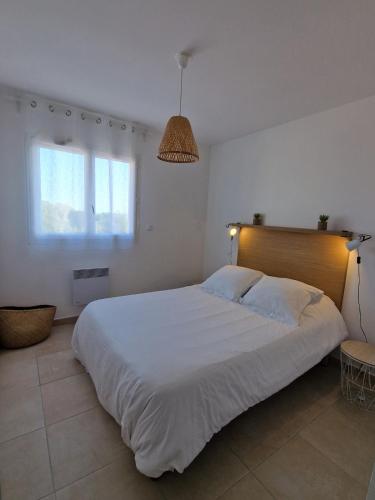 une chambre avec un grand lit blanc et une fenêtre dans l'établissement Apartment with direct beach access Casa Marina, à Linguizzetta