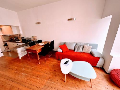 un salon avec un canapé rouge et une table dans l'établissement Grand Palais Bordeaux Centre, à Bordeaux