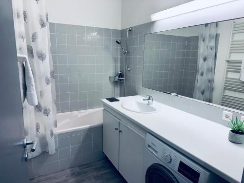 une salle de bain avec un lavabo, un miroir et une baignoire dans l'établissement Grand Palais Bordeaux Centre, à Bordeaux