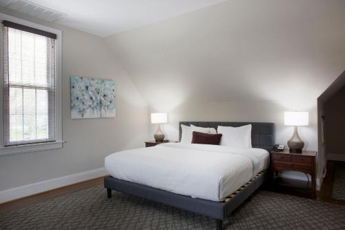 a bedroom with a white bed and two lamps at Normandy Farm Hotel & Conference Center in Blue Bell
