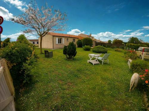 une cour avec un banc et un mouton dans l'herbe dans l'établissement Maison rénové 6 a 8 personnes, à Saint-Pierre-dʼOléron