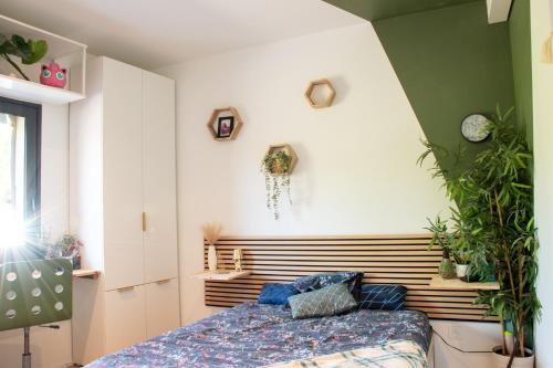- une chambre avec un lit et des plantes sur le mur dans l'établissement Maison Route de l'Océan, à Sainte-Hélène