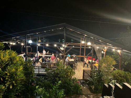 a group of people sitting on a deck at night at Olala Bungalows and Restaurant in Sabong