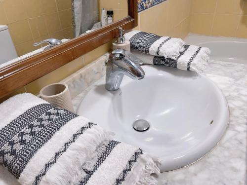 a bathroom sink with towels on a counter at Villa MarySol in Sauzal