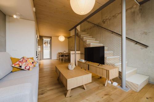 a living room with a couch and a tv and stairs at Urban Chic Townhouse - 2BR Modern Industrial Vibe in Wellington