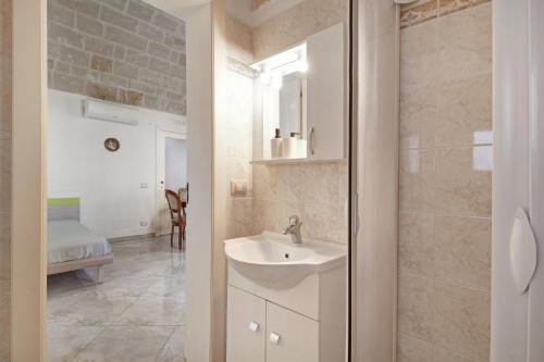 a white bathroom with a sink and a shower at Appartamento Gioberti in Monopoli