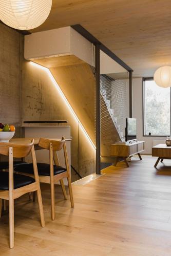 a living room with a table and a staircase at Urban Chic Townhouse - 2BR Modern Industrial Vibe in Wellington