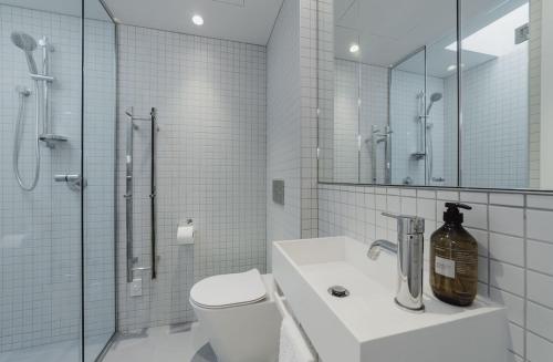 a bathroom with a toilet and a shower and a sink at Urban Chic Townhouse - 2BR Modern Industrial Vibe in Wellington