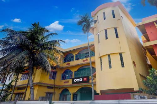 a yellow building with a clock tower at Hotel O Sunrise Guest House in Guwahati