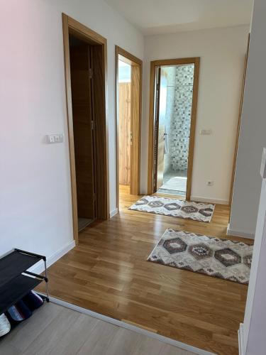 a living room with a wooden floor and a door at ZORA apartmani Sarajevo in Sarajevo