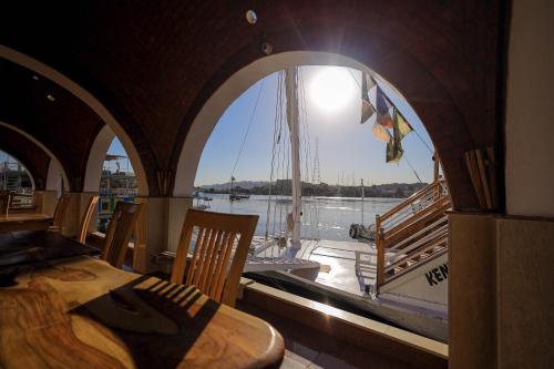a room with a table and a sail boat in a window at Kaya Nubian House in Aswan