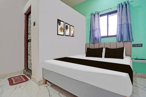 a bedroom with a large bed with a window at Hotel O Galaxy Stay in Chandrapur