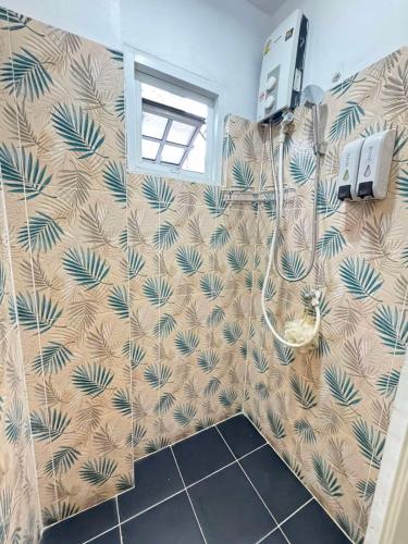 a bathroom with a shower with a palmrative wallpaper at Comfy Crib Hostel in Bangkok