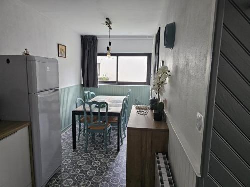 une petite cuisine avec une table et un réfrigérateur dans l'établissement Les Marmottes de Murol, à Murol