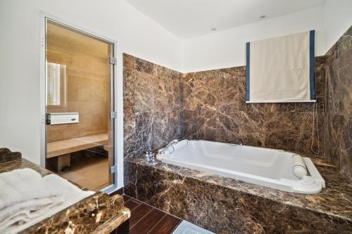 une salle de bain avec baignoire et douche dans l'établissement Villa Tournels Luxury, à Ramatuelle