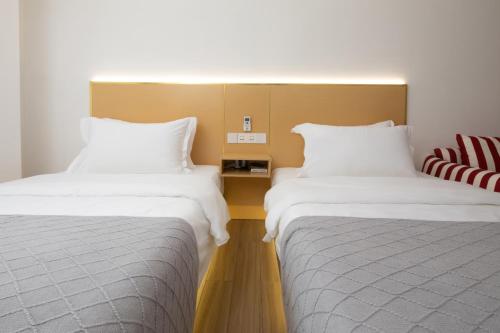 two beds sitting next to each other in a room at Amanda Hotel堆谷里酒店 in Phnom Penh