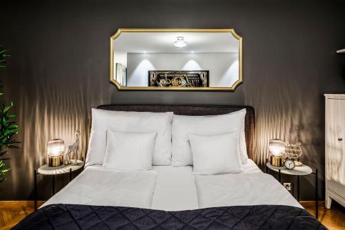 Schlafzimmer mit einem Bett und einem Spiegel an der Wand in der Unterkunft Boutiqueluxury Balcony Ac Downtown in Zürich