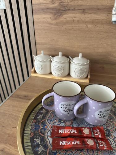 two coffee cups on a table with a plate at ZORA apartmani Sarajevo in Sarajevo