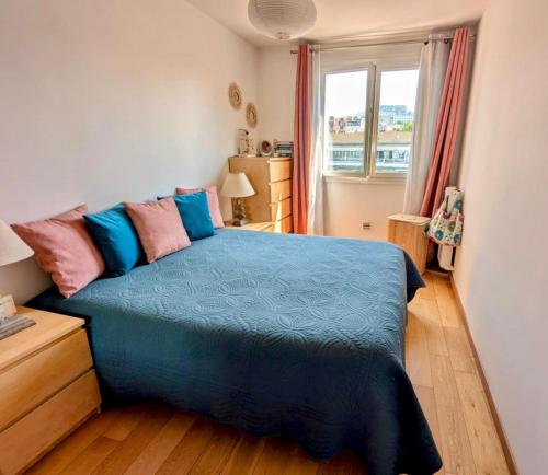 une chambre avec un lit bleu et une fenêtre dans l'établissement Spacieux appartement balcon, à Paris
