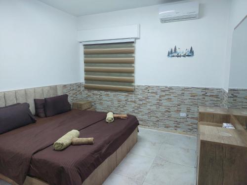 a bedroom with a bed with two stuffed animals on it at Cozy Home 3 in Amman