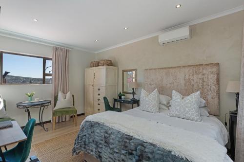 a bedroom with a bed and a desk and a table at Cape Goodness in Bellville