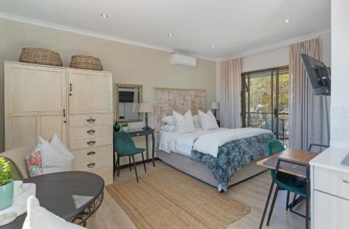a bedroom with a bed and a desk and a table at Cape Goodness in Bellville