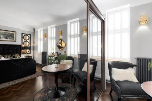 a living room with a table and chairs at Modern & Unique - Central & Beach Access in Swansea