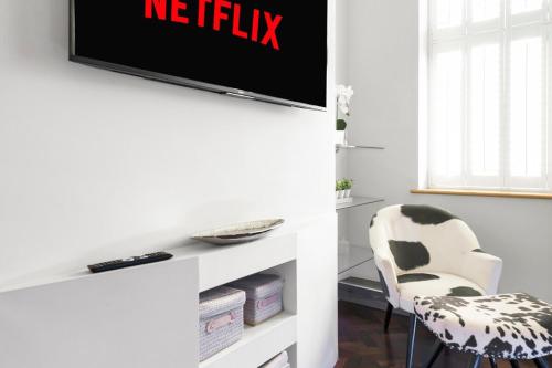 a living room with a tv and a chair at Modern & Unique - Central & Beach Access in Swansea