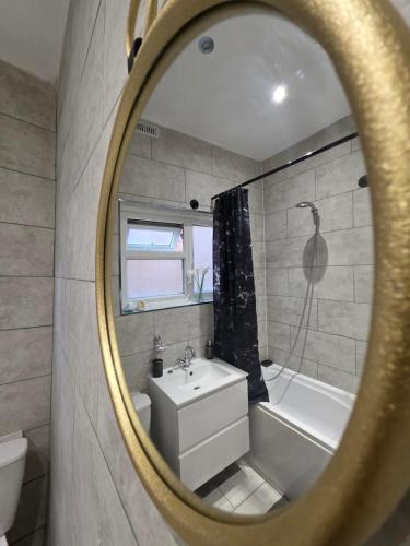 a bathroom with a tub and a sink and a mirror at Charming & Energetic - 8ight Havens Folkestone in Folkestone