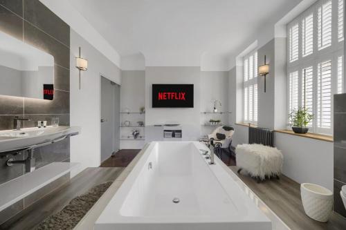 a bathroom with a large tub and two sinks at Modern & Unique - Central & Beach Access in Swansea