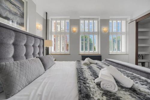 a bedroom with a large bed with two towels on it at Modern & Unique - Central & Beach Access in Swansea