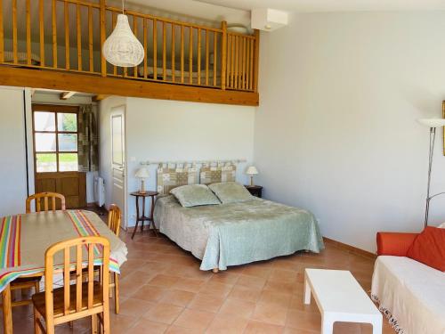 a bedroom with a bed and a couch at Gites le Fabras, espace de verdure, piscine collective et jeux in La Bâtie-Rolland