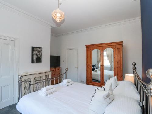 a bedroom with a white bed and a mirror at Royal Victoria House in Scarborough