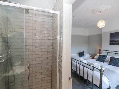 a bathroom with two beds and a glass shower at Royal Victoria House in Scarborough