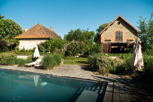 une maison et une piscine devant une maison dans l'établissement Les Jardins des Soussilanges, à Céron
