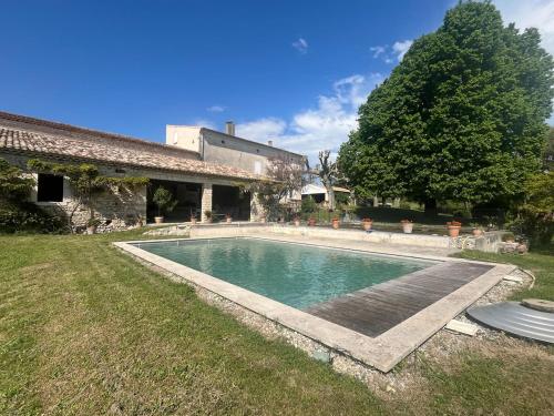 a swimming pool in the yard of a house at Gites le Fabras, espace de verdure, piscine collective et jeux in La Bâtie-Rolland