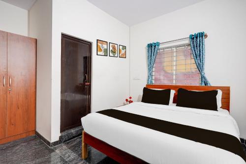 a bedroom with a large bed and a window at Hotel O Sri Krishna Comforts in Bengaluru