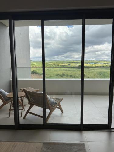 a room with a table and chairs and a window at Sky Sensation Two Rooms Apartment in Moka