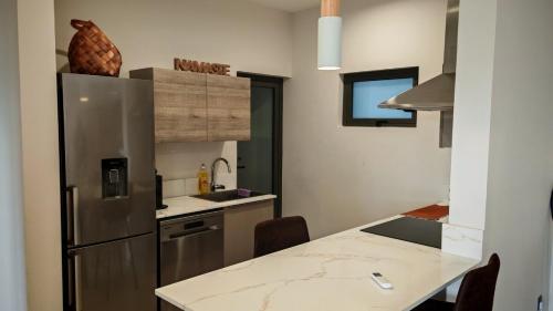 a kitchen with a refrigerator and a table with chairs at Sky Sensation Two Rooms Apartment in Moka